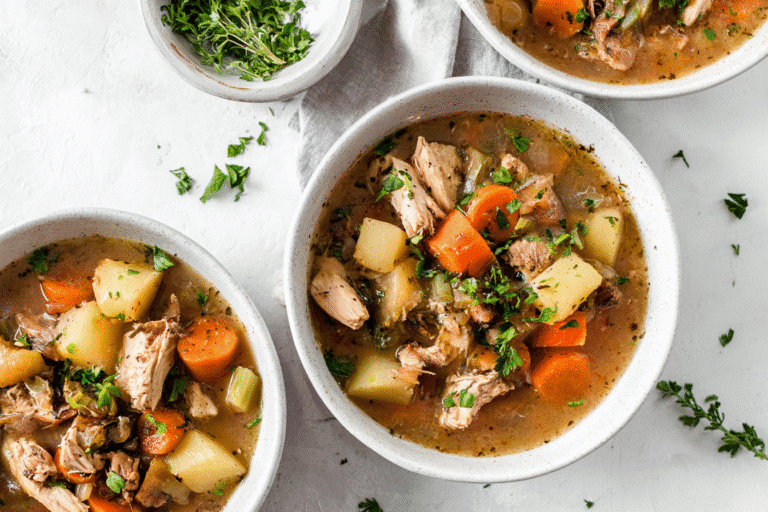 Three bowls of hearty slow cooker chicken stew with tender chicken, carrots, potatoes, celery, onions, and herbs in a savory broth. Garnished with parsley, rustic food styling, soft natural daylight,